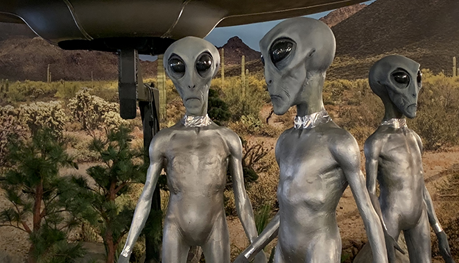 Three roswell aliens standing on the land